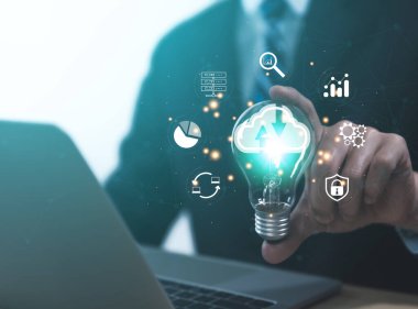 Businessman holding a light bulb showing a diagram of Cloud computing information technology icon. Concept of big data digital connection on communication networks. storage security internet service