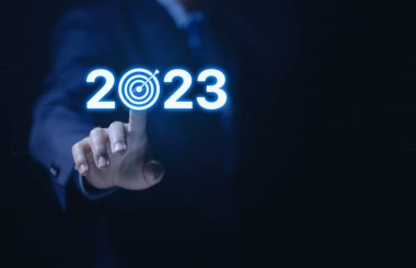 İş adamı eli 2023 'ü gösteriyor. Yatırım girişimi konsepti. 2023 yılının hedef ve stratejilerinin uygulanması, gelecekteki başarı için iş büyümesi finansal değişim yönetimi