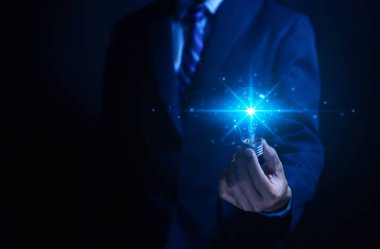 İş adamı elinde bir ampul dijital teknolojisi tutuyor. Yaratıcı ve yenilikçi bir fikir hayal et. İş dünyasındaki beyin fırtınasından beyin fırtınasına. Geliştirme, büyüme ve başarı stratejileri