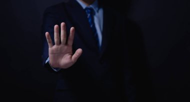 Erkek eli, dur işareti gösteriyor. Şiddeti durdur kavramı. Uyarı, yasaklama, inkar. Koyu arkaplanda.