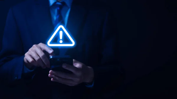 警告の三角形と感嘆符のアイコンを示すスマートフォンを使用してビジネスマン危険な問題の警告サーバーエラー ウイルスだ メンテナンスコンセプト 注意してくださいインターネット技術ネットワークセキュリティ — ストック写真