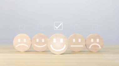Tahta blok gülen bir simge gösteriyor. Müşteri kavramları, memnuniyet anketleri, olumlu geri bildirim Ürün kullanıcı deneyiminden en iyi yanıt servisi.