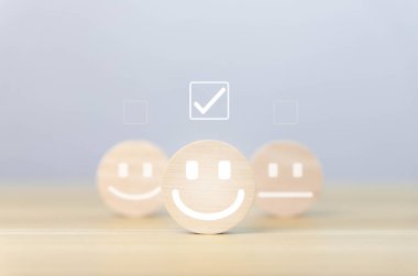 Tahta blok gülen bir simge gösteriyor. Müşteri kavramları, memnuniyet anketleri, olumlu geri bildirim Ürün kullanıcı deneyiminden en iyi yanıt servisi.