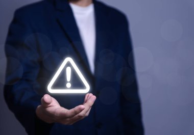 İş adamı elinde uyarı üçgeni ve ünlem işareti simgesi var. Tehlikeli sorunlara karşı uyarma sunucu hatası. Virüs. Bakım konsepti. dikkat internet teknolojisi ağ güvenliği
