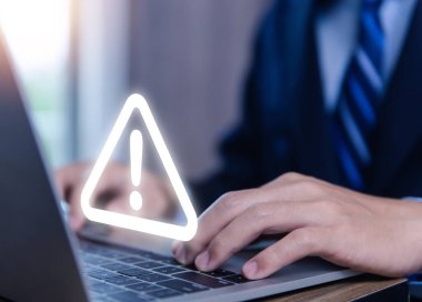 Businessman using laptop showing warning triangle and exclamation sign icon Warning of dangerous problems Server error. Virus. Maintenance concept. caution internet technology network security