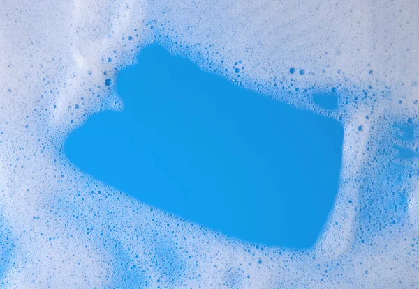 top view liquid white foam from soap or shampoo or shower gel. Abstract bubbles. on a blue background