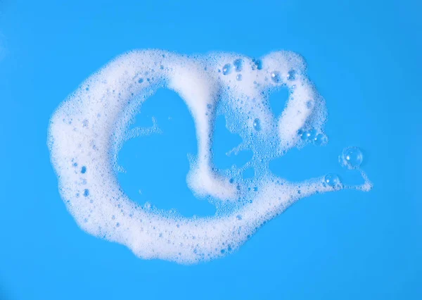 top view liquid white foam from soap or shampoo or shower gel. Abstract bubbles. isolated on a blue background