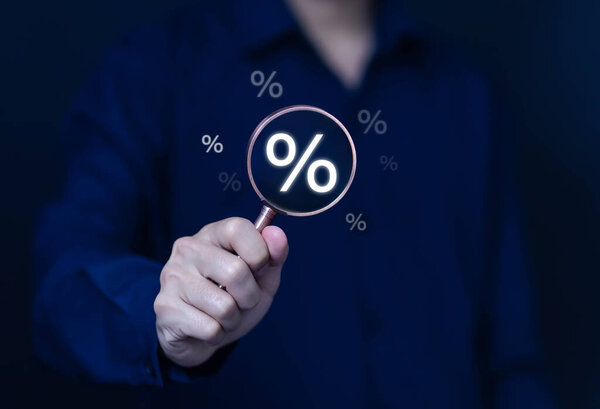 Предприниматель держит увеличительное стекло показывая процент подписать бизнес-инвестиционную концепцию, увеличить прибыль, финансы, маркетинг, продажа, процентная ставка