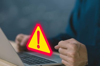 Businessman using laptop showing warning triangle and exclamation sign icon Warning of dangerous problems Server error. Virus. Maintenance concept. caution internet technology network security