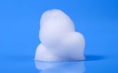Beyaz köpük sabun köpüğü, şampuan sıvısı dokusu ve köpük deterjanı. Temizleyici ürün konsepti. Mavi bir arkaplanda izole edilmiş