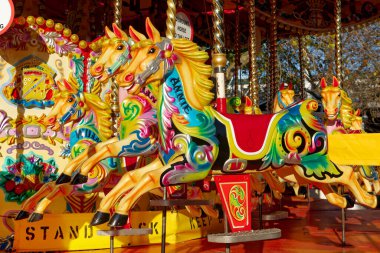 Beautifully decorated carousal horses on a merry-go-round clipart