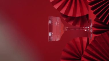 Çin Yeni Yıl arkaplanında bir bardak gül şampanyası ve kağıt yelpaze. Geleneksel Asya kültür dekorasyonu. Uzayı kopyala, dikey 4k video