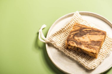 Beton tabaktaki el yapımı doğal sabun ya da şampuan çubukları. Küçük işletmeler için çevre dostu güzellik konsepti. Yeşil arkaplanda sıfır atık hediyesi