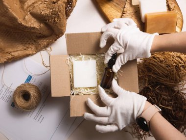 Paramparça beyaz kağıt üzerinde serum şişeleri olan bir güzellik kutusu. Çevre dostu karton hediye kutusu ve sıfır atık kozmetik ürünleri. Teslimat servisi deposunda çevrimiçi mağaza siparişleri.