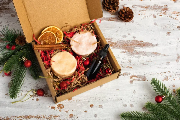 Christmas beauty box with solid bars of shampoo and body wash on red and brown shredded pink paper packing material. Delivery of fragile objects