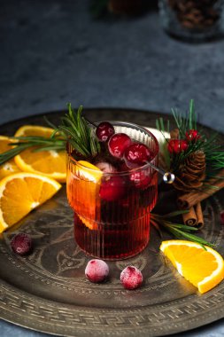 Buzlu ve biberiyeli yabanmersinli Noel kokteyli. Portakal, böğürtlen, tarçın ve anason ile şenlikli bir içecek..