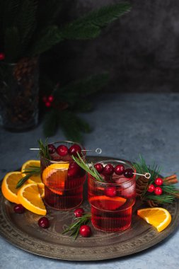 Buzlu ve biberiyeli yabanmersinli Noel kokteyli. Portakal, böğürtlen, tarçın ve anason ile şenlikli bir içecek..