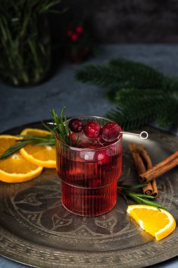 Buzlu ve biberiyeli yabanmersinli Noel kokteyli. Portakal, böğürtlen, tarçın ve anason ile şenlikli bir içecek..