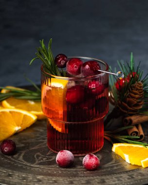 Buzlu ve biberiyeli yabanmersinli Noel kokteyli. Portakal, böğürtlen, tarçın ve anason ile şenlikli bir içecek..