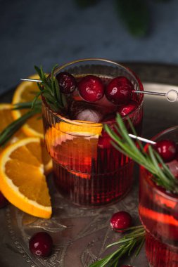 Buzlu ve biberiyeli yabanmersinli Noel kokteyli. Portakal, böğürtlen, tarçın ve anason ile şenlikli bir içecek..