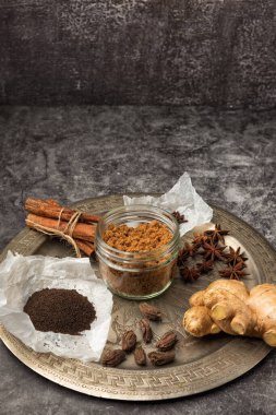 Hint Masala Çayı 'na baharat. Yiyecek ya da bitki çayı karışımı. Tarçın çubukları, yeşil kakule tohumları ve gri dokuda anason..