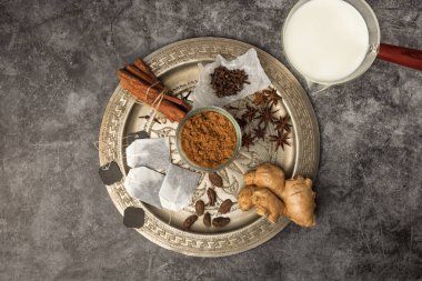 Hint Masala Çayı 'na baharat. Yiyecek ya da bitki çayı karışımı. Tarçın çubukları, yeşil kakule tohumları ve gri dokuda anason..