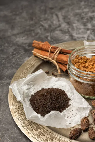 Hint Masala Çayı 'na baharat. Yiyecek ya da bitki çayı karışımı. Tarçın çubukları, yeşil kakule tohumları ve gri dokuda anason..