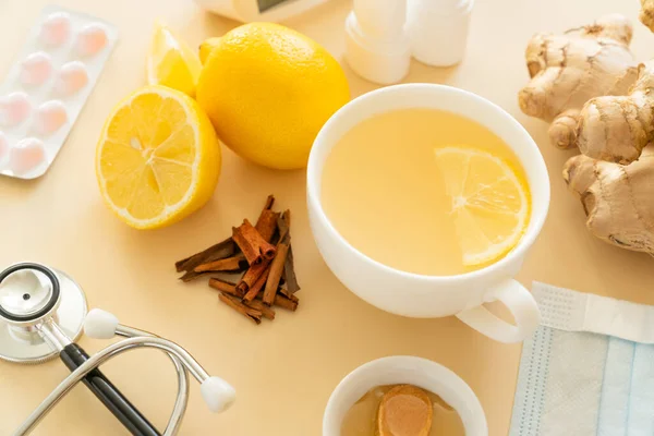 Natural cold remedies concept - ginger tea and ingredients, drugs, thermometer. High quality photo