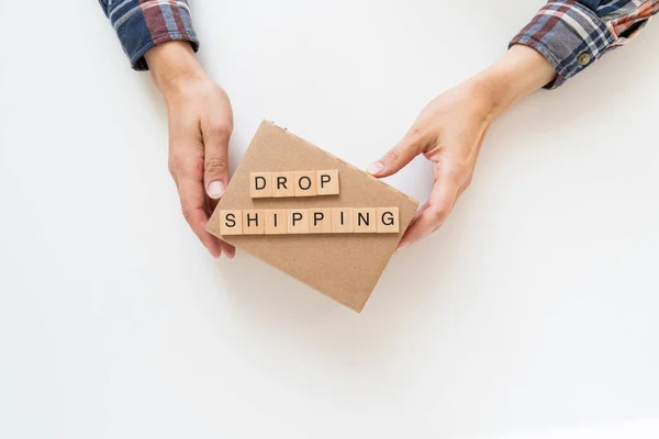 Drop shipping concept - hands holding carton box, top view