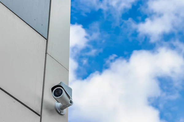 Security control camera or CCTV on cloudy sky background.
