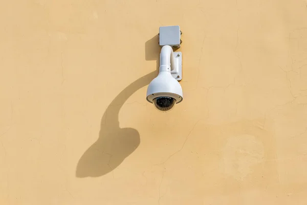 Security control camera or CCTV on a wall background.