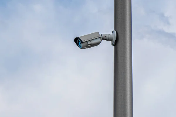 Security control camera or CCTV on cloudy sky background.