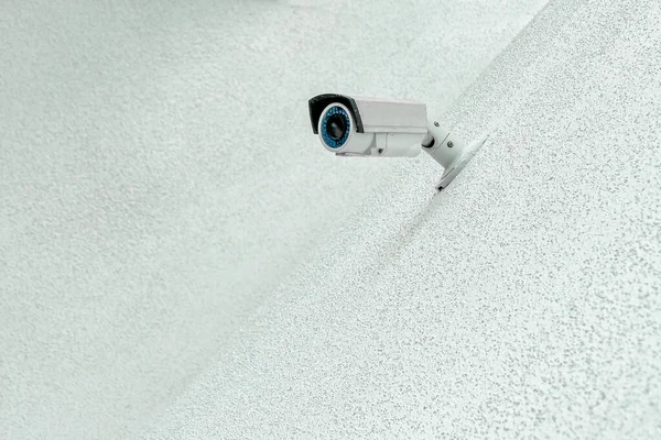 Security control camera or CCTV on a wall background.