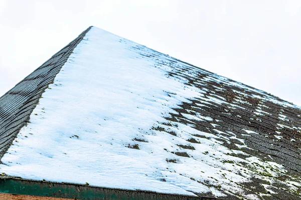 A thin layer of snow on the roof tile. Winter weather concept.