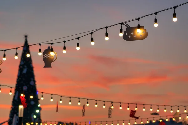 Christmas garlands with LED lamps against the twilight sky. Xmas decorations.