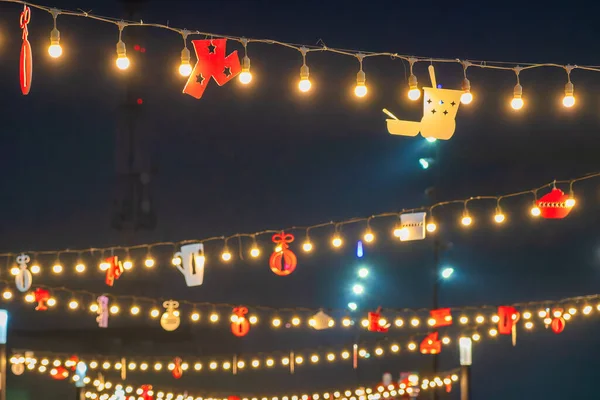 Christmas garlands with LED lamps against the black night sky. Xmas decorations.