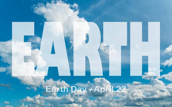 Lettering Earth Day April 22 on the background of cloudy sky. Earth day concept, protection of the planet from pollution, improvement of environmental ecology and nature conservation.