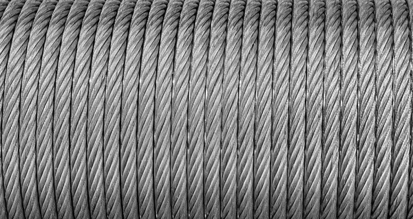 The texture of a new stainless steel cable wrapped in a spool. Abstract background for desin.