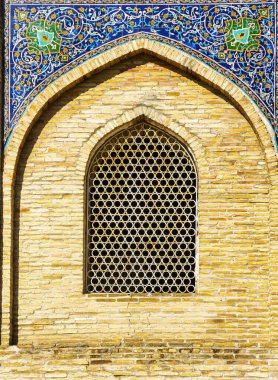 Müslüman bir caminin penceresi, geometrik yuvarlak İslami bir süs şeklinde parmaklıklar ardında. Soyut mozaik arkaplan.