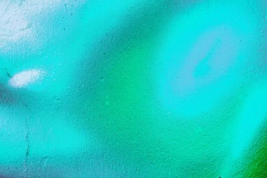 A fragment of colorful graffiti painted on a wall. Abstract urban background for design. Spray painting art.