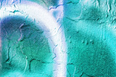 A fragment of colorful graffiti painted on a wall. Abstract urban background for design. Spray painting art.