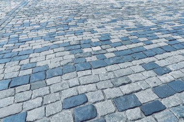 The texture of a stone old monotonous pavement with a perspective.