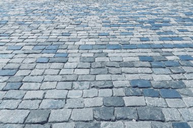 The texture of a stone old monotonous pavement with a perspective.