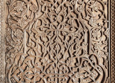 Fragment of an ancient carved wooden door. Ornate background.