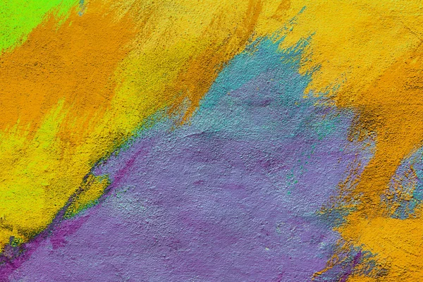 A fragment of colorful graffiti painted on a wall. Abstract urban background for design. Spray painting art.