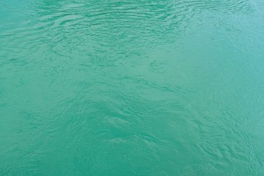 The texture of the waves of turquoise color of fast-flowing water in the river. Abstract nature background.