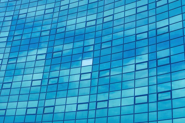 stock image Fragment of a modern office building. Abstract geometric background. Part of the facade of a skyscraper with glass windows.