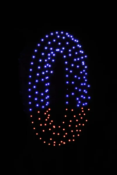 在漆黑的夜空背景上显示出五彩斑斓的无人驾驶灯光 一个数字为零的数字 0由发光的无人驾驶飞机构成 — 图库照片