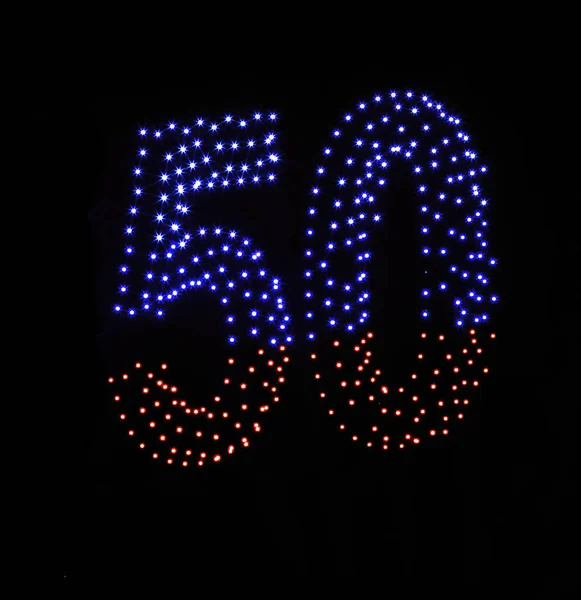 在漆黑的夜空背景上显示出五彩斑斓的无人驾驶灯光 一个50 50的数字 由发光的无人驾驶飞机做成 — 图库照片