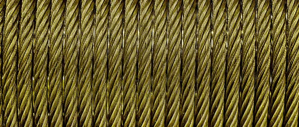 The texture of a new golden color cable wrapped in a spool. Abstract background for desin.